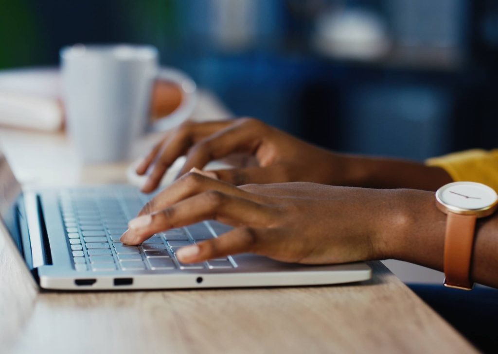 Close up of a woman's hands using a laptop