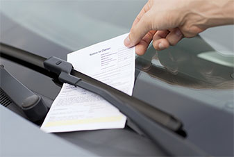 Parking ticket under a car windshield wiper